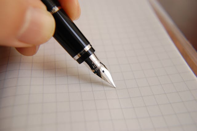 Plume qui écrit sur une feuille